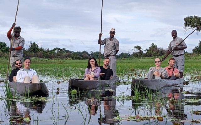 Guests on a mokoro safari in the Okavango Delta with local polers guiding traditional dugout canoes